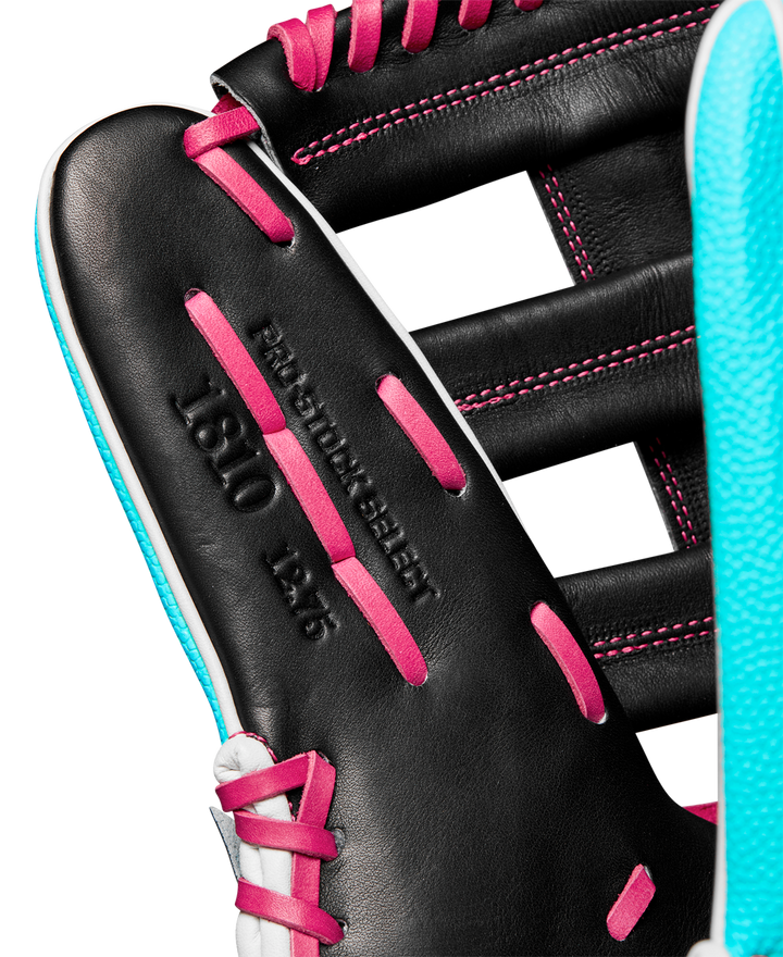 Close-up of a black Wilson A2K 1810SS 12.75" baseball glove with pink laces, light blue trim, and "PRO STOCK SELECT 1810 12.5" embossed on the leather. Model: WBW1026881275, Winter 2024 collection.