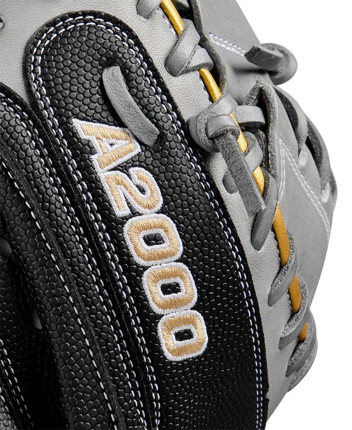 Close-up of the Wilson A2000 FPCM23 34" Fastpitch Catcher's Mitt in black and gray with yellow accents, made from Pro Stock leather and featuring white and gold "A2000" embroidery on the side.