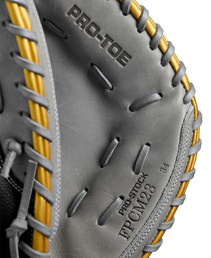 Close-up of the Wilson A2000 FPCM23 34" Fastpitch Catcher's Mitt (WBW10274434) by Wilson, featuring gray Pro Stock leather, gold lacing, and embossed "PRO-TOE," "PRO-STOCK," and "JPCML23" inside the pocket.