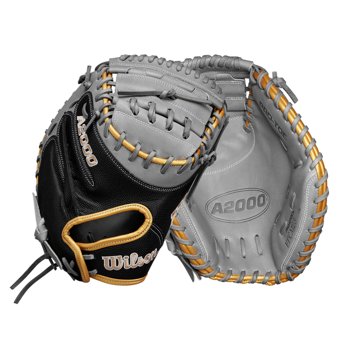 Two Wilson A2000 FPCM23 34" Fastpitch Catcher's Mitts are shown; one palm-up and one palm-down, highlighting the black, gray, and tan Pro Stock leather, webbing, detailed stitching, and the Wilson brand logo.