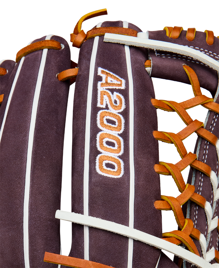 Close-up of a Wilson A2000 T125 12.5" Aliyah Andrews GM Fastpitch Glove (WBW102745125), a brown leather outfield glove with orange and white laces, featuring the embroidered A2000 logo, inspired by Aliyah Andrews.