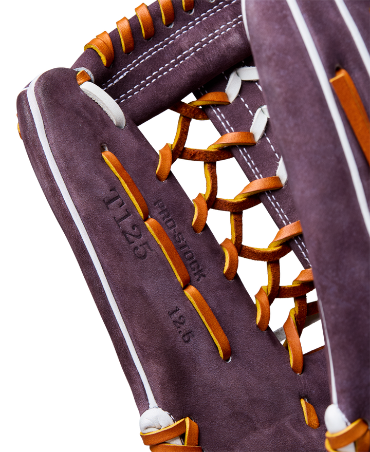 Close-up of a Wilson A2000 T125 12.5" Aliyah Andrews GM Fastpitch Glove (WBW102745125) in purple with orange laces and white stitching, featuring "11.25," "pro stock," and "12.6" stamped on the palm.