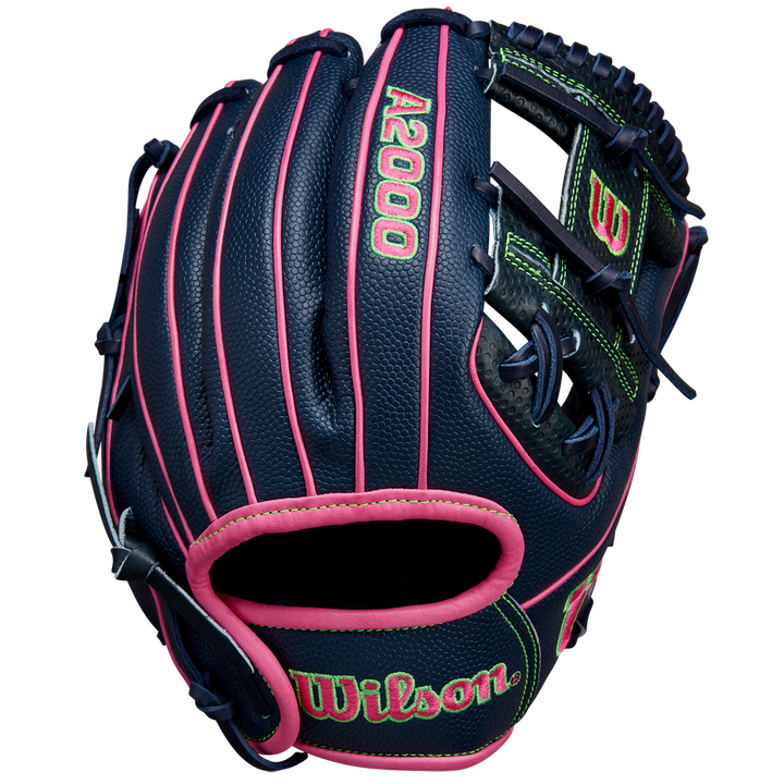 The Wilson A2000 DP15SS 11.5" Baseball Glove (SPRING 2025: WBW102747115) features a navy blue design with pink laces, neon green stitching, Pedroia Fit Technology, and Wilson branding on the wrist strap.