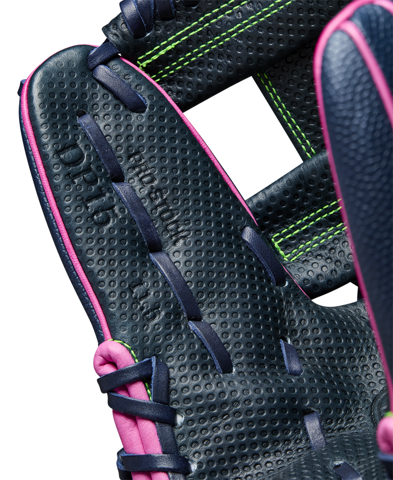 Close-up of the Wilson A2000 DP15SS 11.5" Baseball Glove (WBW102747115)—navy blue leather, pink edging, dark blue laces, bright green stitching, and Pedroia Fit Technology. Detailed craftsmanship with embossed text inside palm.