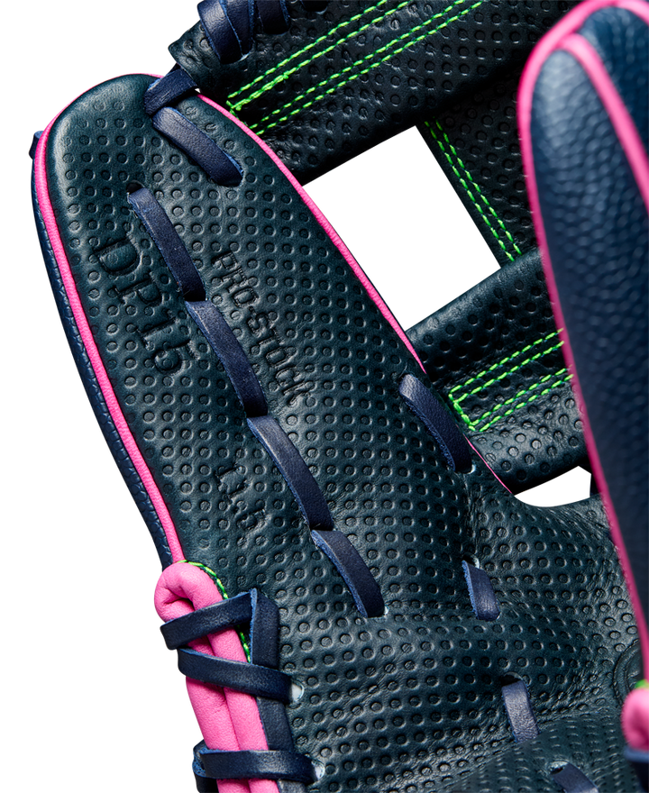 Close-up of the Wilson A2000 DP15SS 11.5" Baseball Glove (WBW102747115)—navy blue leather, pink edging, dark blue laces, bright green stitching, and Pedroia Fit Technology. Detailed craftsmanship with embossed text inside palm.