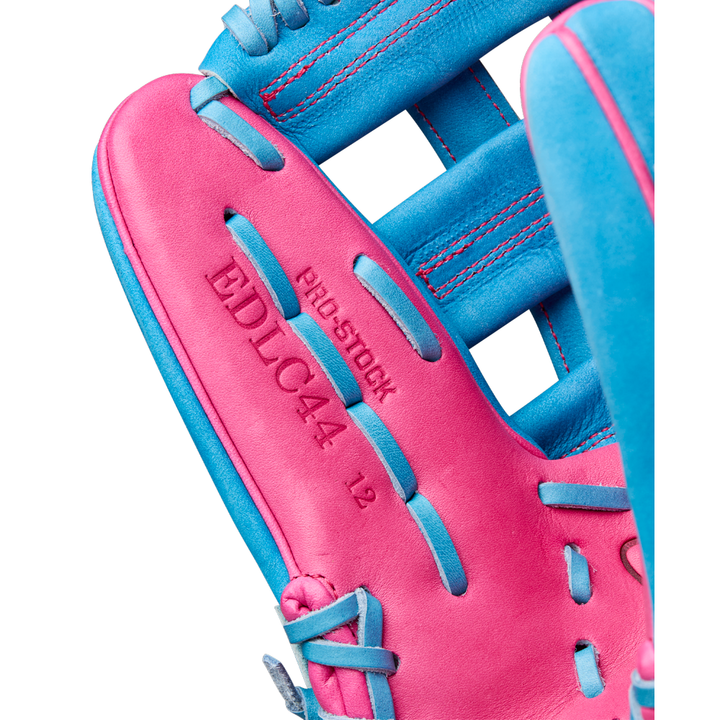 Close-up of the Wilson A2000 EDLC44 12" Elly De La Cruz Gameday Baseball Glove in bright pink and blue, featuring embossed text "PRO STOCK," "EDLC44," and "12" on the palm—ideal as a 12” infield glove. Model: WBW10345212, FALL 2025.