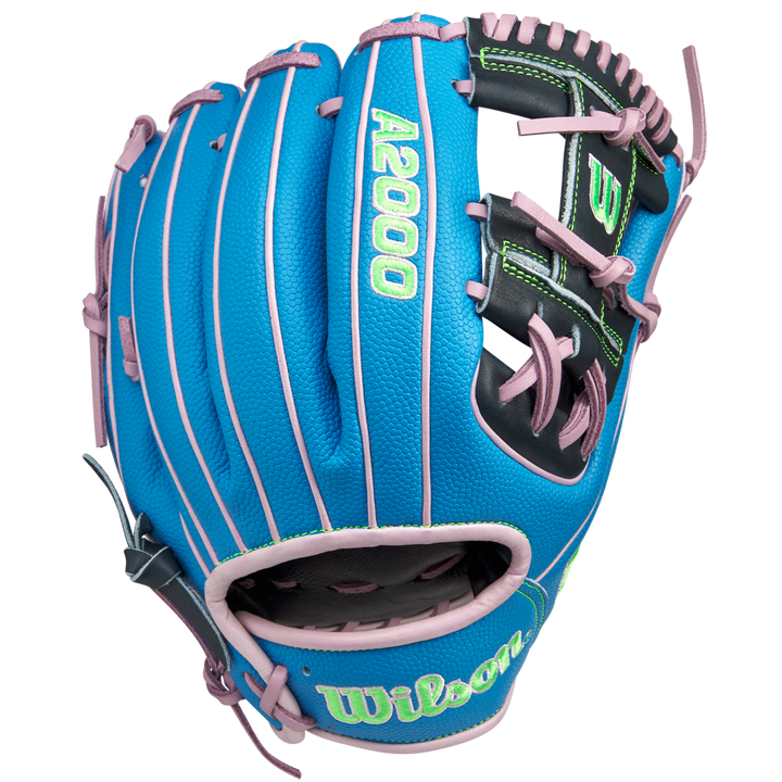 The Wilson A2000 1786SS 11.5" GOTM March 2025 glove (WBW103479115) features blue SuperSkin, pink lacing and trim, a black palm area, and green embroidered lettering. Shown on a white background. Brand: Wilson.