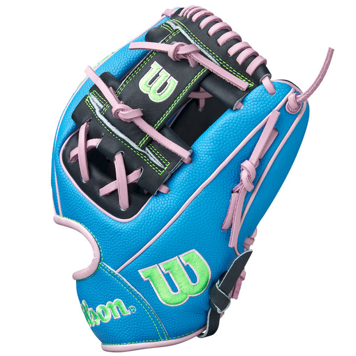 The Wilson A2000 1786SS 11.5" Baseball Glove (GOTM March 2025, WBW103479115) features a blue design with black, green, and pink accents, pink laces, green W logos, Pro Stock leather, and is shown upright on a white background.