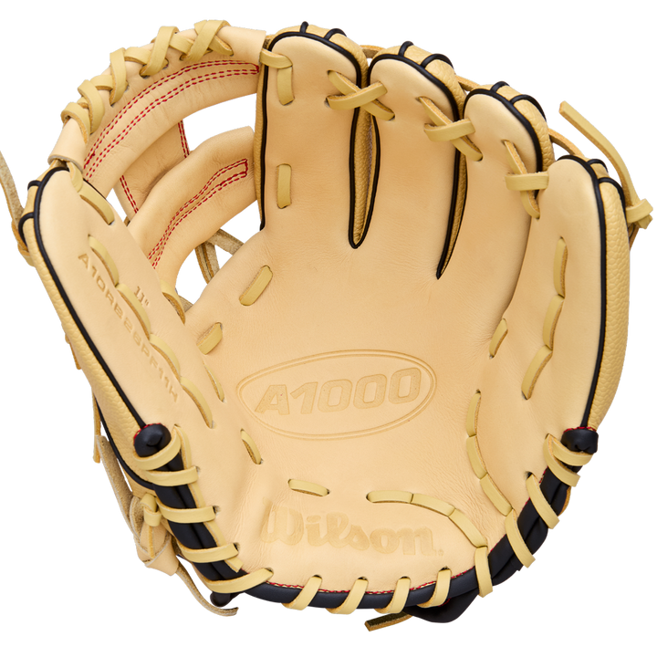 The Wilson A1000 PF11 11" Baseball Glove (WBW10395511) is a tan infield glove with black lacing, red stitching, Pedroia Fit for a snug feel, and brand logos plus model info on the leather.