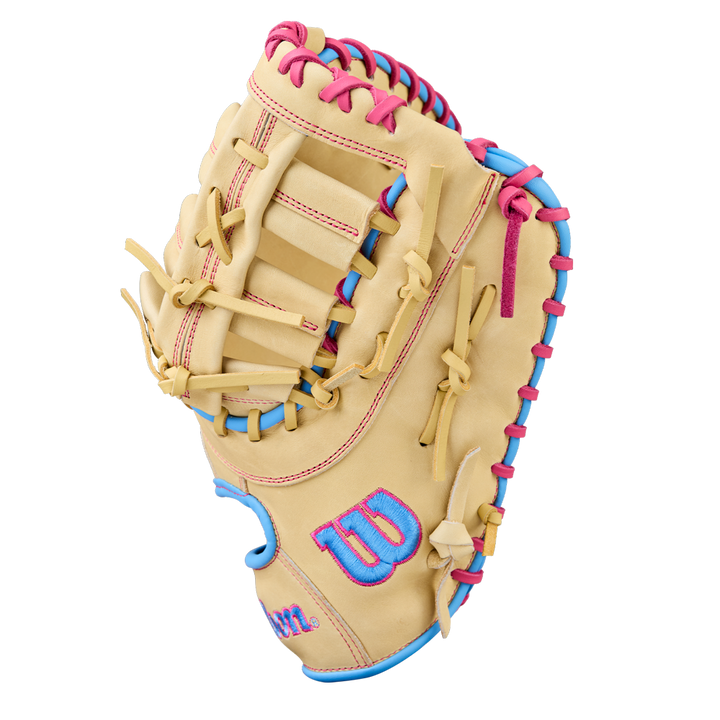 The Wilson A1000 1620 12.5" Baseball First Base Mitt (WBW103967125) is a tan youth glove made of full grain leather with pink and blue laces and a blue Wilson W logo outlined in pink on the thumb, shown on a white background.