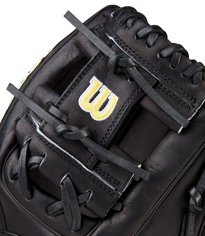 Close-up of a Wilson A2000 1788 11.25" baseball glove, crafted from black Pro Stock Leather with black laces and a yellow embroidered W logo on a strap near the webbing.