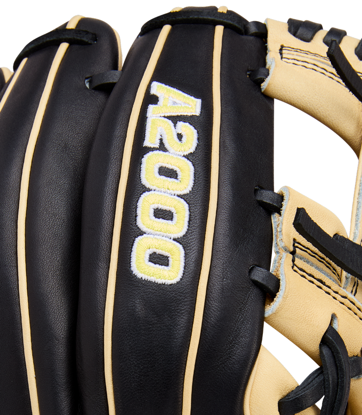 Close-up of the Wilson A2000 1786 11.5" Baseball Glove (WBW104108115) in black and tan, featuring white and yellow A2000 embroidery, crafted from Pro Stock Leather with contrasting stitching and durable H-Web construction.