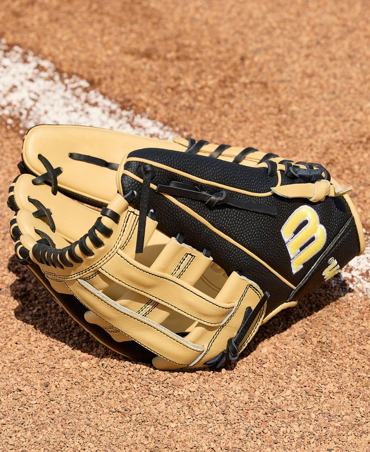 A Wilson A2000 DW5 12" Baseball Glove (WBW10411612) in tan and black with Pro Stock Leather and visible stitching rests on a dirt field next to the white chalk baseline.