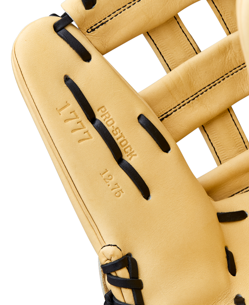 Close-up of a Wilson A2000 1777 12.75" Baseball Glove (WBW1041231275) outfield glove in tan with black laces. Stamped text reads 1777, Pro Stock, and 12.75 on the Pro Stock Leather; stitching and texture are clearly visible.