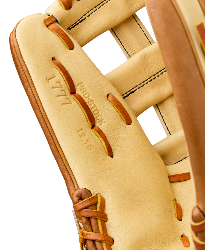 Close-up of the Wilson A2000 1777 12.75" Baseball Glove featuring tan Pro Stock Leather, visible stitching, and laces. The inner palm displays "1777," "PRO STOCK," and "12.75," highlighting its premium Wilson craftsmanship.