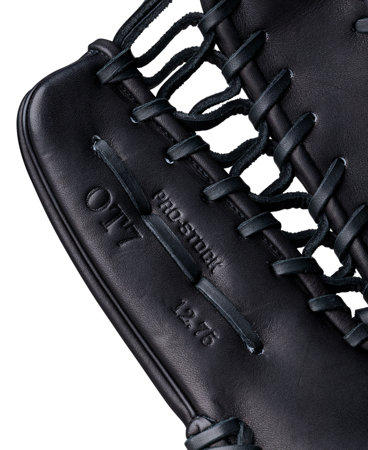 Close-up of a black Wilson A2000 OT7 12.75" Baseball Glove (WBW1041811275), highlighting its laces and embossed text reading “PRO STOCK,” “OT7,” and “12.75.”.