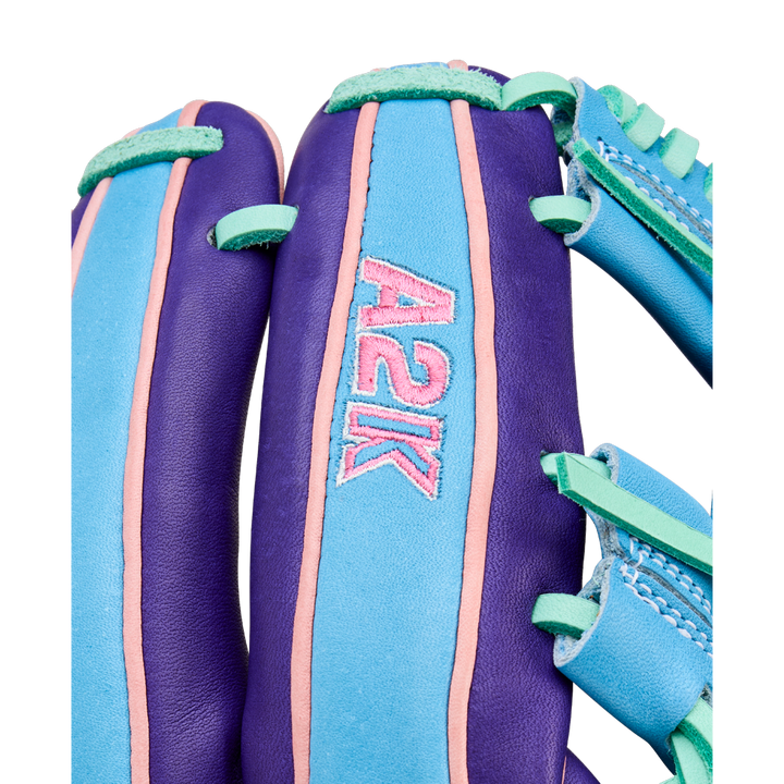 A close-up of the Wilson A2K 1720 11.5" Baseball Glove - GOTM October 2025 shows vibrant purple, teal, and pink accents with "A2K" stitched in pink, crafted from premium Pro Stock Select leather for elevated performance.