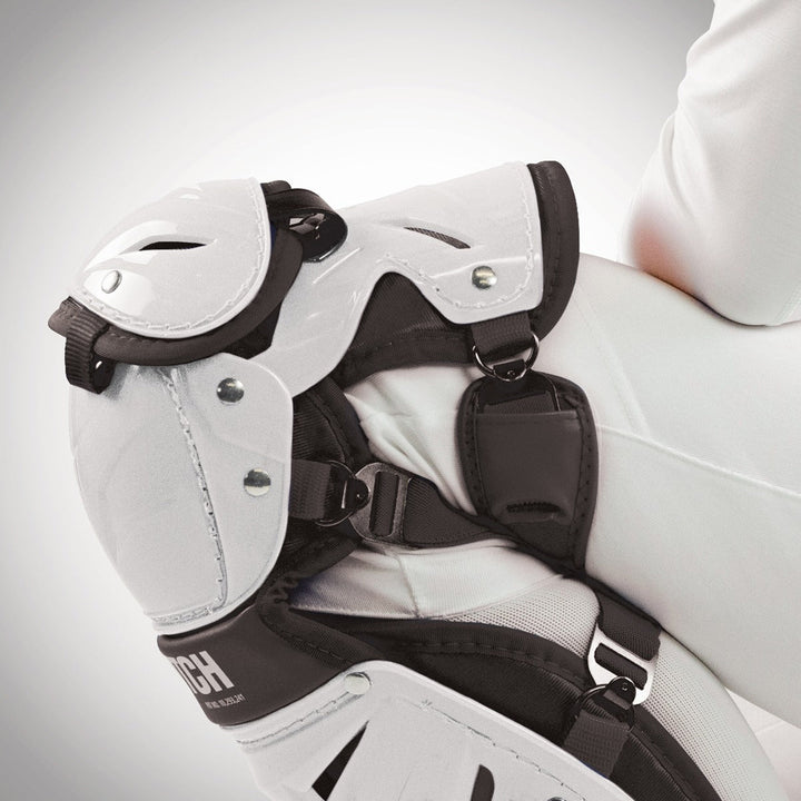 A close-up of a person wearing All Star AFx Fastpitch Catcher's Leg Guards: LGW-AFX, focusing on the knee and upper leg with securely fastened pads and straps, showcasing advanced women’s protection from All Star.