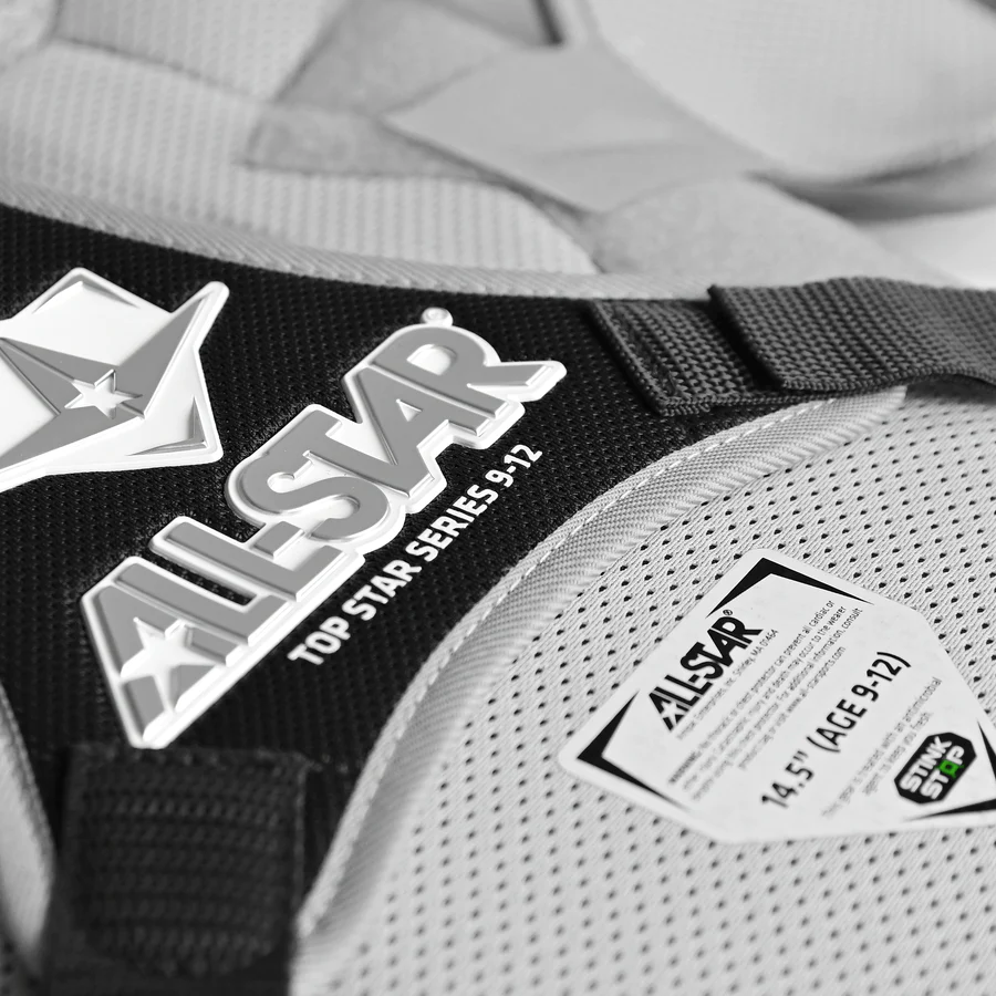 Close-up of the All Star Top Star Catcher's Chest Protector: CPCC-TS in black and gray for ages 9-12 (14.5"), featuring the All Star logo, Top Star Series, and a NOCSAE standard label.