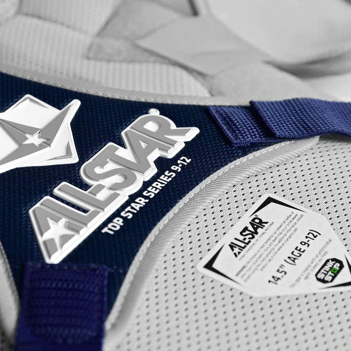 Close-up of an All Star Top Star Catcher's Chest Protector: CPCC-TS in navy blue/gray, NOCSAE approved, with “ALL-STAR TOP STAR SERIES 9-12” logo and size 14.5" (AGE 9-12)—perfect for travel ball catchers. Mesh fabric background.