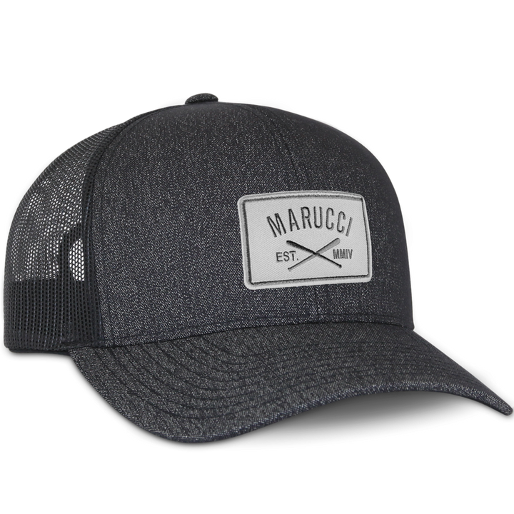 The Marucci Cross Patch Snapback Hat (MAHTTRPCS) is a black trucker mesh baseball cap with a light gray front patch displaying the Marucci logo above crossed bats and "EST. MMIV," plus an adjustable snapback closure.