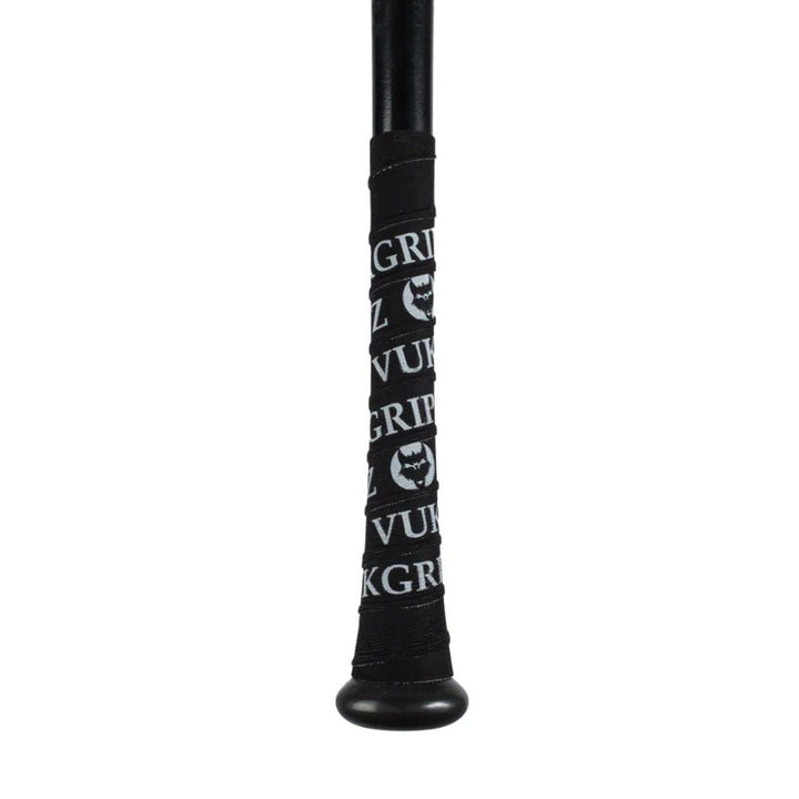 Close-up of a VukGripz Bat Grip Tape-wrapped black bat handle, featuring repeating white "VukGripz" text and wolf head logo for superior grip.