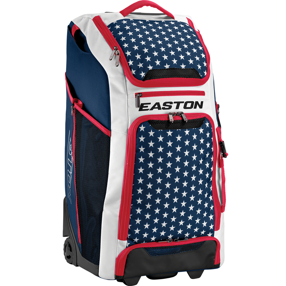The Easton A159058 CATWB Catcher's Wheeled Bag features a blue, white, and red color scheme with white stars on blue, red zippers, rugged inline wheels, a telescopic handle, and EASTON branding displayed on the front.