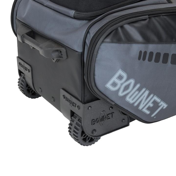 Close-up of the Bownet Commander Wheeled Catcher's Bag (BN-COMMANDER BAG) with rugged wheels, black and gray design, and "BOWNET" in bold whiteâideal for durable baseball equipment storage.