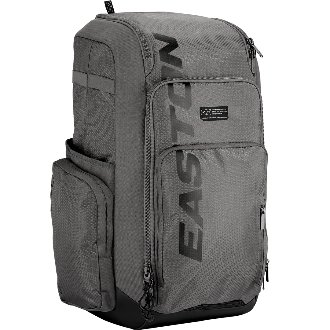 The Easton Roadhouse Backpack (EBA004) by Easton is a gray slowpitch backpack with multiple zippered compartments, side pockets, and "EASTON" printed vertically in black—ideal as a baseball or softball backpack.