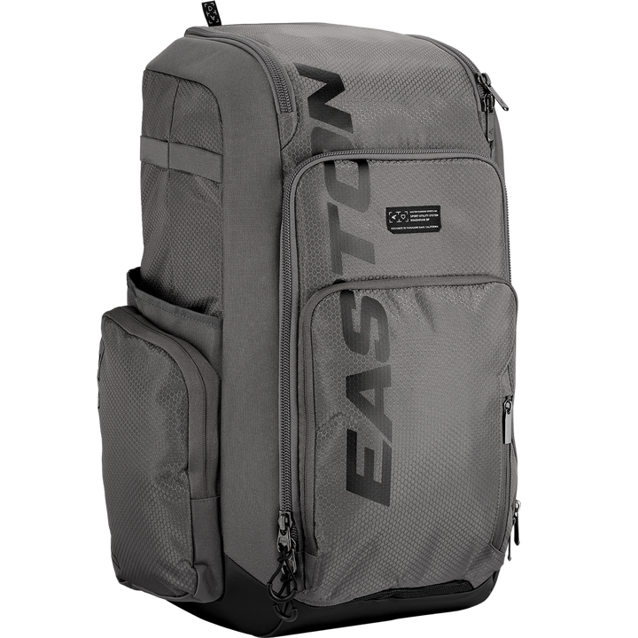 The Easton Roadhouse Backpack (EBA004) by Easton is a gray slowpitch backpack with multiple zippered compartments, side pockets, and "EASTON" printed vertically in black—ideal as a baseball or softball backpack.