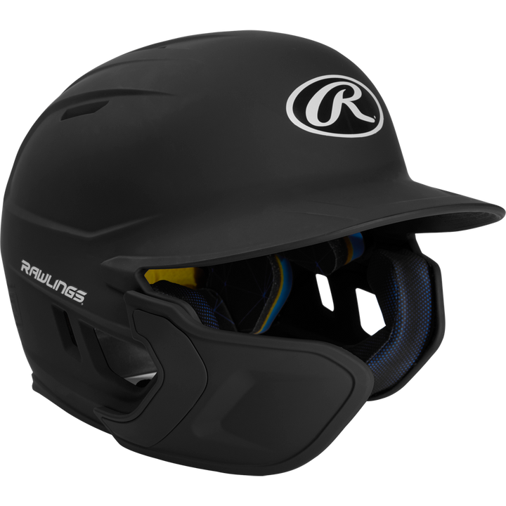 A black Rawlings Mach Matte Batting Helmet with EXT flap (MACHEXT), featuring a protective face guard, padded interior, and Rawlings logos on the front and side, displayed on a plain white background.
