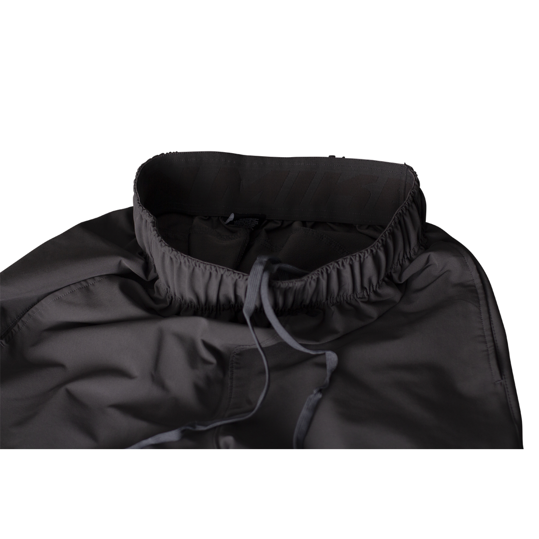 Close-up of Miken Men's Slowpitch Shorts (MSPSM20) by Miken, paired with a dark gray, high-collared jacket featuring an elastic drawstring at the neck, displayed on a plain white background.