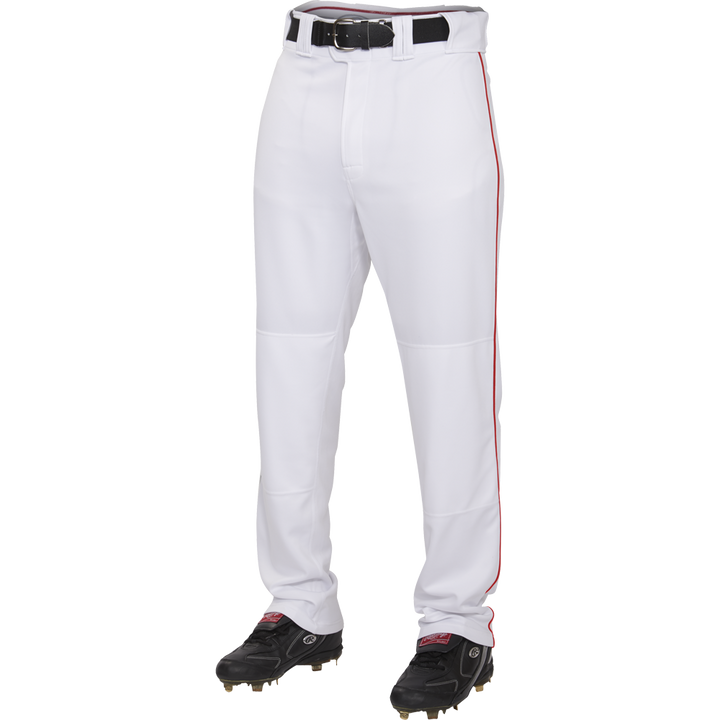 A person wears Rawlings Adult Premium Semi-Relaxed Baseball Pants with Piping (PRO150P), made of 100% polyester with a thin red stripe, paired with a black belt and black cleats, standing against a plain white background.