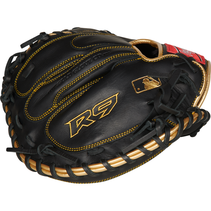 A Rawlings R9 32.5" baseball catcher's mitt (R9CM325BG) in black with gold stitching and accents, featuring the R9 logo and a gold MLB logo near the thumb.