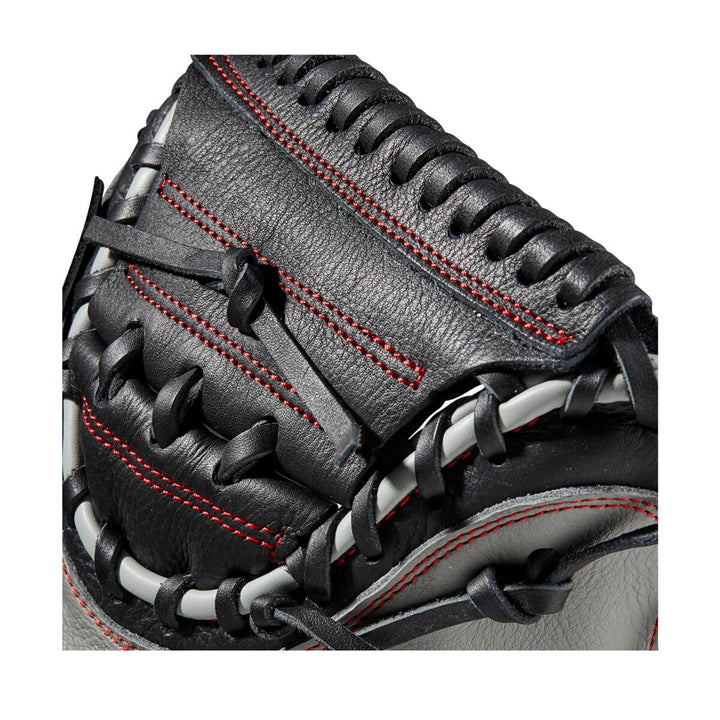 Close-up of the Wilson A500 32" Baseball Catcher's Mitt by Wilson, featuring top grain leather in black and gray with red stitching, black laces, detailed craftsmanship, and an adjustable wrist closure for a secure fit.