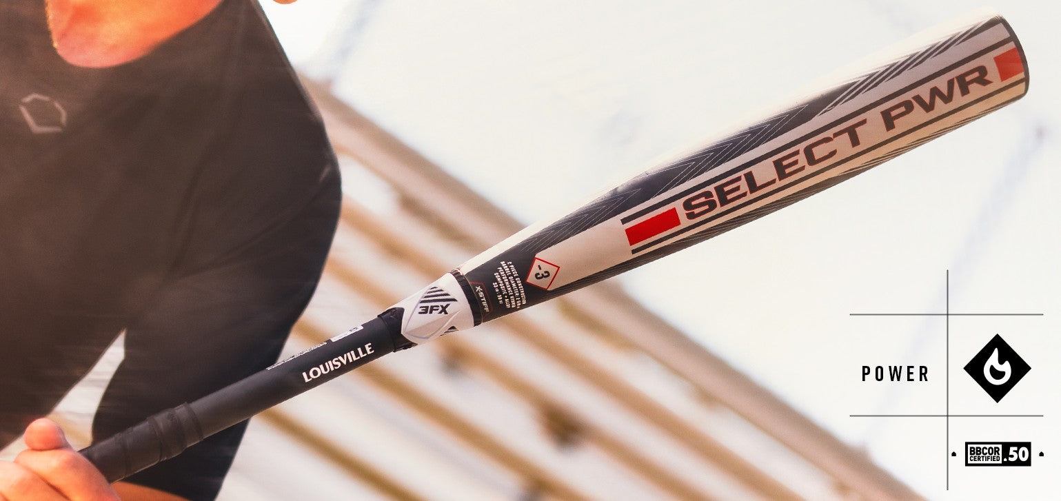 Close-up of a person holding a Louisville Select PWR baseball bat, angled upward, with sunlight shining on the bat and blurred background. The bat features black, red, and silver graphics.