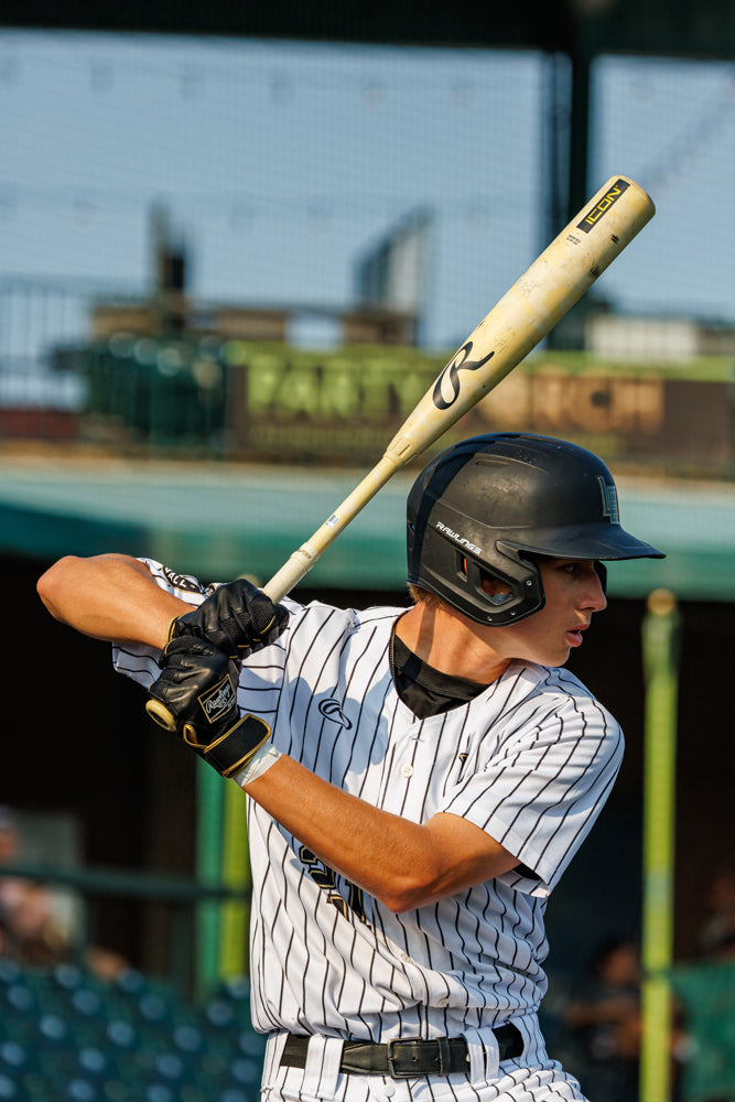 A man holding a 2025 Rawlings Icon (-3) BBCOR Baseball Bat: RB5I3 (DEMO).