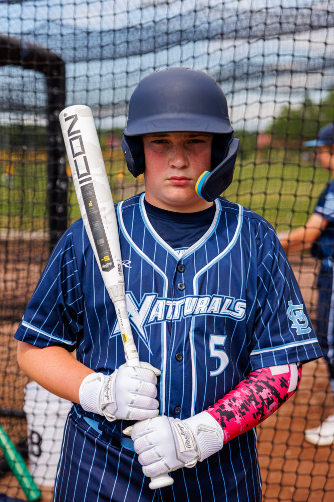 A boy holding a 2025 Rawlings Icon (-5) 2 3/4" USSSA Baseball Bat (RUT5I5), highlighting Rawlings' newest carbon composite bat technology.