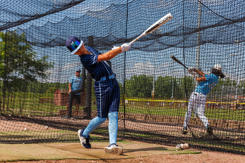 A boy swings a 2025 Rawlings Icon (-5) 2 3/4" USSSA Baseball Bat (RUT5I5), a carbon composite bat by Rawlings.