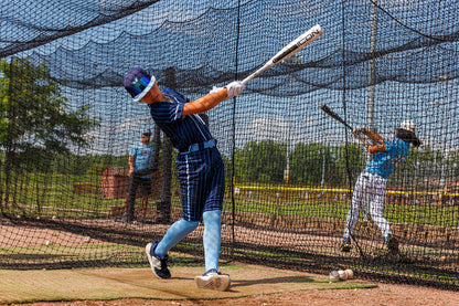 A boy swings a 2025 Rawlings Icon (-5) 2 3/4" USSSA Baseball Bat (RUT5I5), a carbon composite bat by Rawlings.