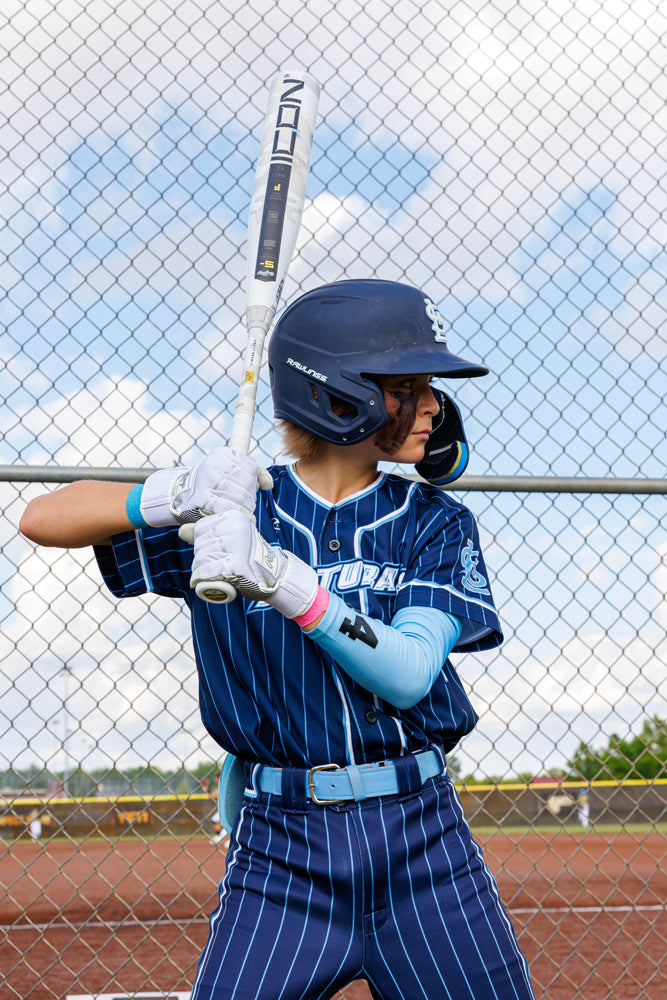 A boy holding a 2025 Rawlings Icon (-5) 2 3/4" USSSA Baseball Bat (RUT5I5), a premium carbon composite model from Rawlings.
