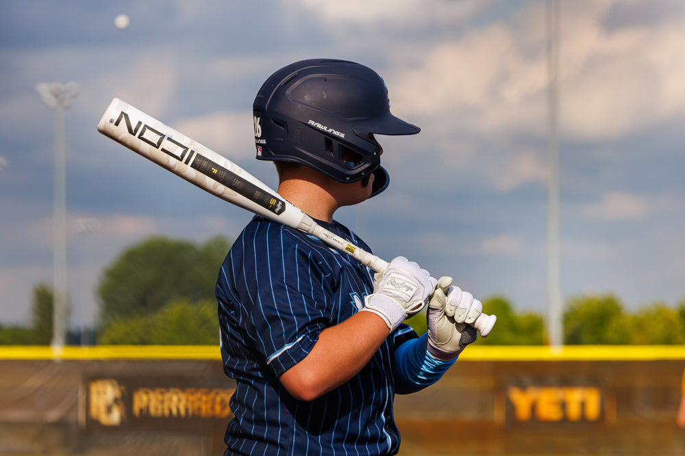 A man holding a 2025 Rawlings Icon (-5) 2 3/4" USSSA Baseball Bat (RUT5I5) by Rawlings.