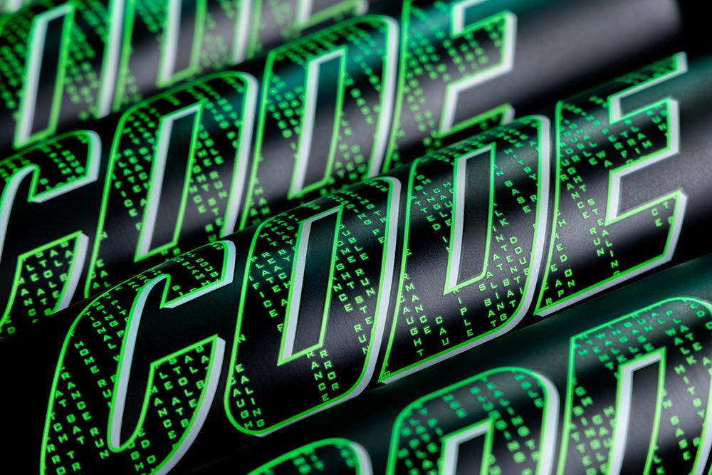 Close-up of the word CODE in bold, green letters with a digital matrix-style effect, mirroring the precision of the Marucci 2025 Code (-3) BBCOR Baseball Bat (MCBCD). Small green digits fill each letter on a sleek black background.