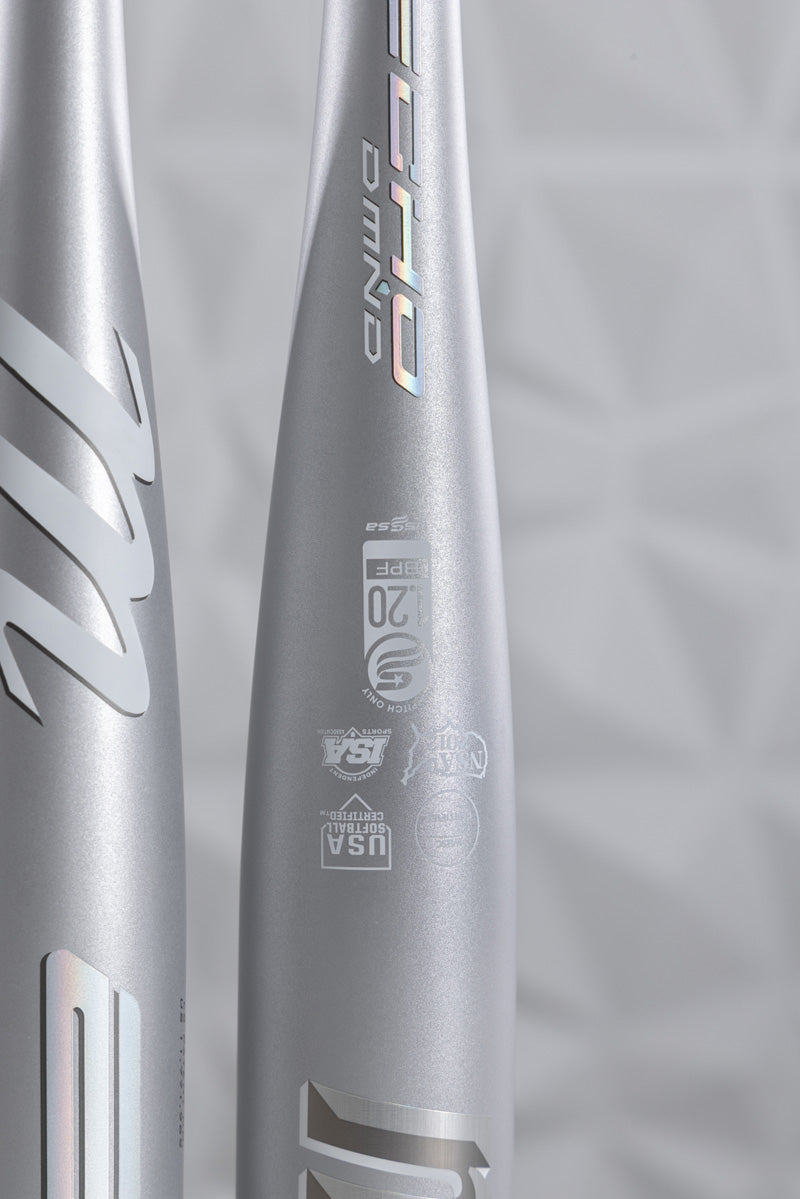 Close-up of the Marucci 2025 Echo DMND2 (-9) Fastpitch Softball Bat (MFPED29), featuring holographic logos, USA Baseball and BBCOR certifications, and a visible liquid-gel knob, set against a light gray geometric background.