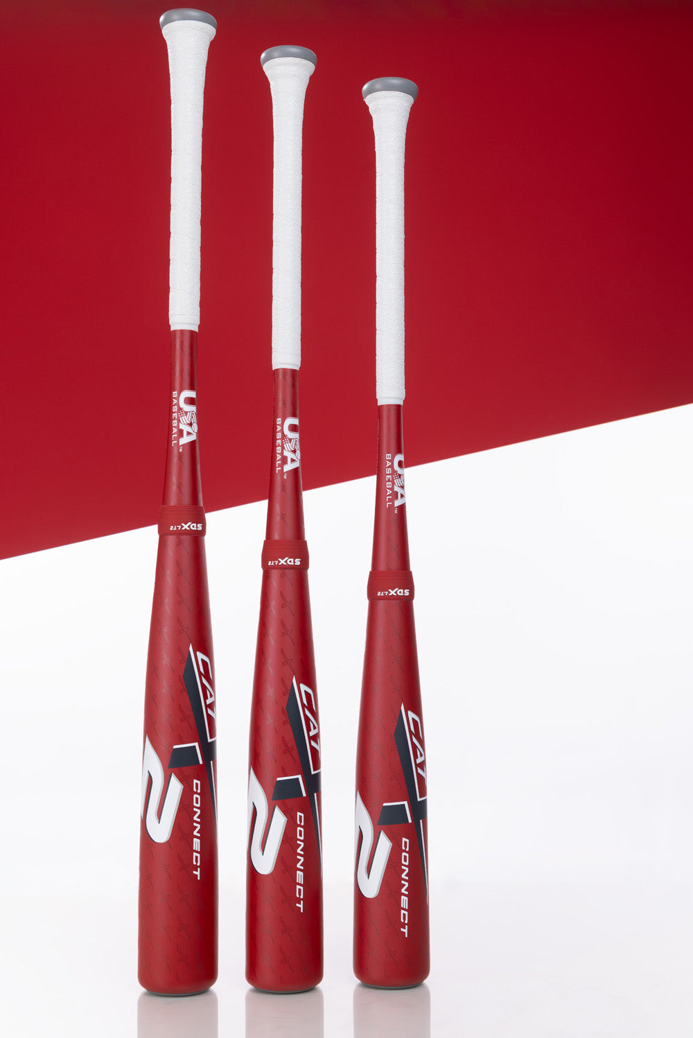 Three Marucci CATX2 Connect (-8) USA Baseball Bats with white handles stand upright against a red and white background. These two-piece hybrid bats show the USA Baseball logo near the handle.