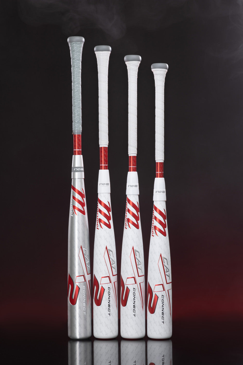 Four Marucci CATX2 Connect (-5) USSSA baseball bats with white grips and red accents stand upright against a dark background, their two-piece hybrid design reflecting below as mist swirls overhead.