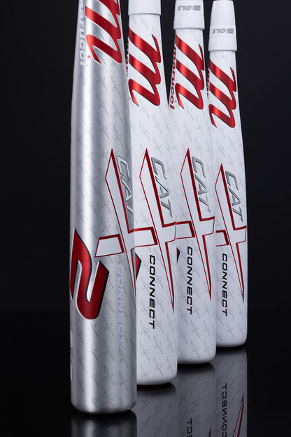 Four 2025 Marucci CATX2 Connect (-3) BBCOR Baseball Bats (MCBCCX2), three in white and one in silver, stand upright on a reflective black surface, showcasing the Marucci brand name, red accents, and anti-vibration design features.