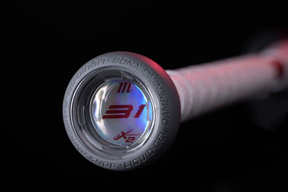 Close-up of the Marucci 2025 CATX2 Connect (-5) USSSA Baseball Bat handle, featuring a clear end cap with red M 31 logo and LIQUID-GEL DAMPENING KNOB for anti-vibration, set against a black background.