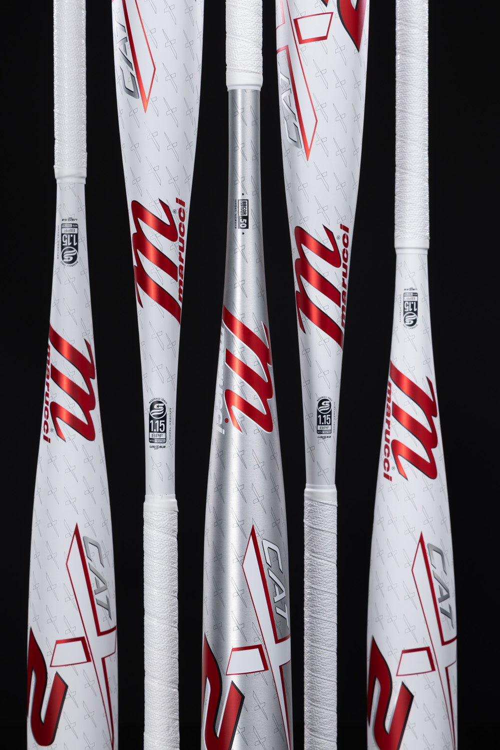 Five Marucci CATX2 (-10) 2 3/4" USSSA Baseball Bats by Marucci stand vertically against a black background, showing white and silver color, red logos, grip tape, certification stamps near the barrels, and one-piece alloy construction.