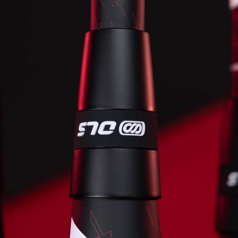 Close-up of a black bicycle component with the white logo SLR and a stylized graphic on it, set against a black and red blurred background.